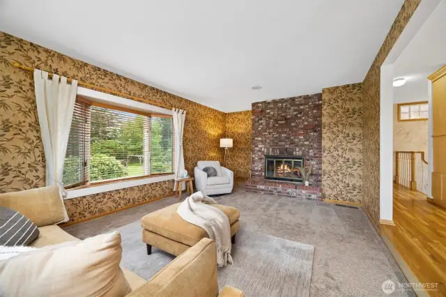 The living room has a lovely bay seat that looks toward the southerly rear yard. There is a brick fireplace with a hearth for extra seating.