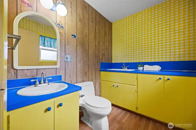 The half bath on the lower level is light and bright and has a deep laundry sink.