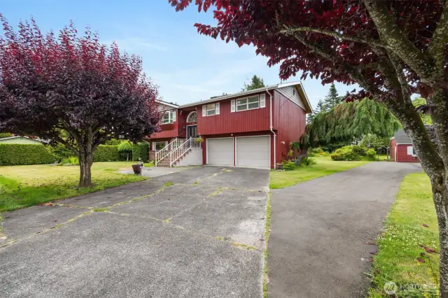 There is so much parking and the entire half acre parcel is level. The driveway to the right goes back to the work shop.