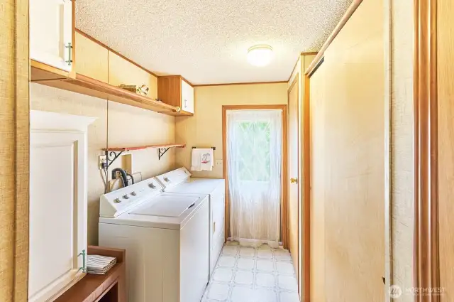 Utility room with lots of storage and door to rear of house.