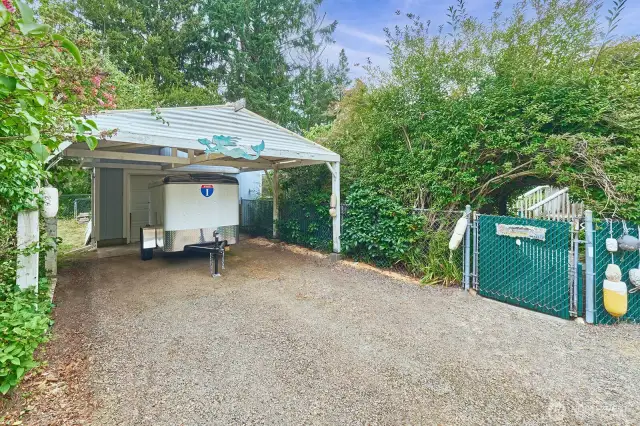 Carport expands your covered parking space. Back gate is covered with a living arch.