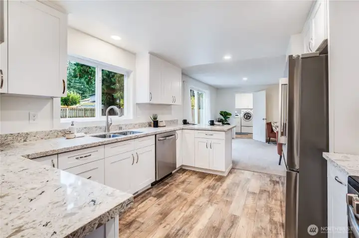 The kitchen features new quartz countertops, white soft-close cabinets, new stainless appliances, and new fixtures.