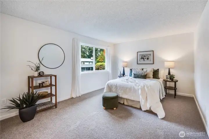 On the upper level of the home, you'll find the primary suite. It is spacious enough for a full furniture ensemble.