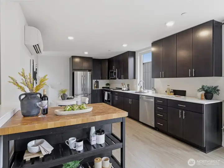 The kitchen has sleek stainless steel appliances and quartz countertops