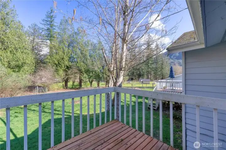 Private deck off primary. Beyond the backyard gate (left in foto) lies a wooded, partially cleared section of the property ~ ready for your personal use and creative vision.