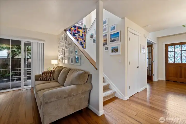 Nice wide stairs leads to the second story and serves as a backdrop to the cozy living room; complete with glass sliding door to covered porch.