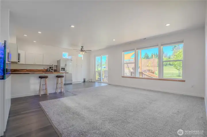 Nine foot ceilings plus big windows and a walkout to the deck makes this great room live large and brings the outdoor views in. Windows have custom shades.