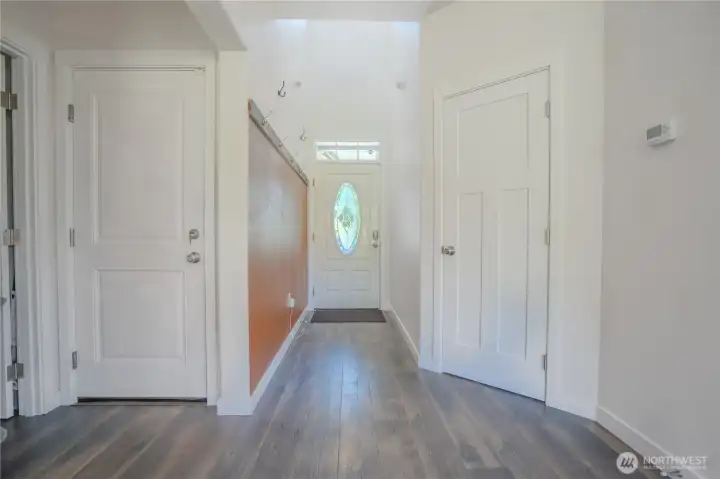 Front entry with leaded glass window. Garage access door on left, closet on right.  Solid wood doors throughout.