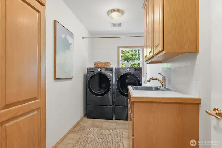 A generously sized laundry room offers exceptional functionality with built-in storage, a convenient wash sink, and ample space for everyday routines. A generously sized laundry room offers exceptional functionality with built-in storage, a convenient wash sink, and ample space for everyday routines.