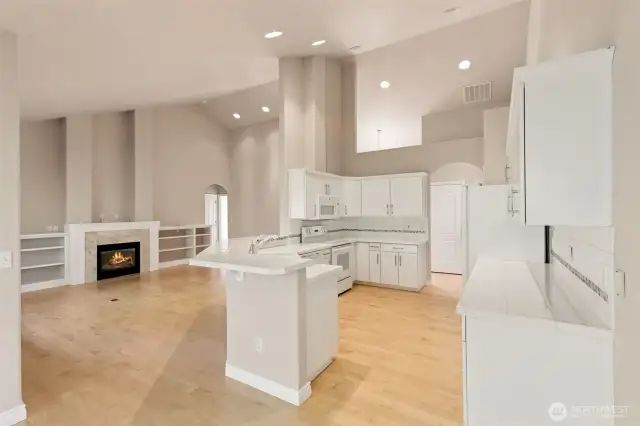 View from dining towards kitchen and living area. Maple hardwood flooring throughout.  Vaulted ceilings.
