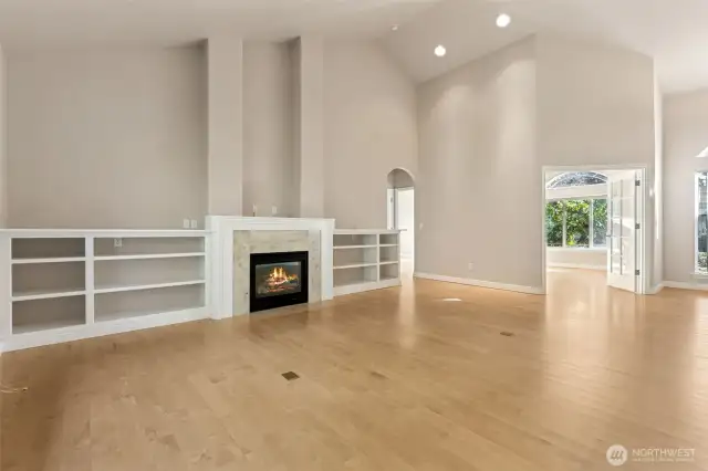 Living area, gas fireplace, built in shelving, maple floors.