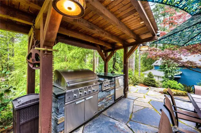 This spectacular covered, outdoor kitchen has a 9 foot counter; large grill, two burners, 2 Haier refrigerator drawers and lighting.
