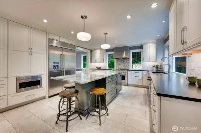 Thoughtfully designed commercial-style kitchen with plentiful storage and room to join in the action at the island.