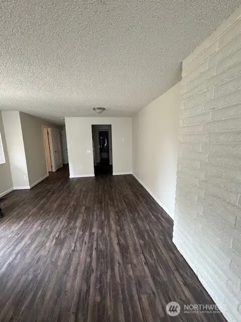 Living room facing dining area, kitchen and bedrooms