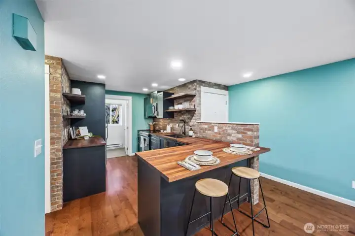 The kitchen features a reclaimed brick backsplash