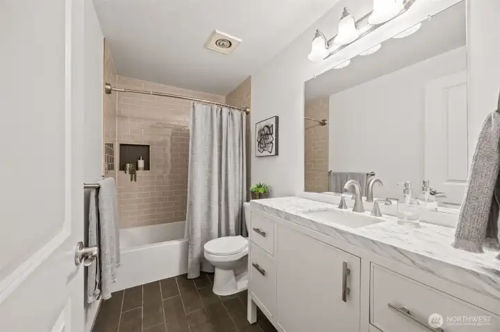 Bright bathroom featuring modern finishes and a tiled tub/shower combo