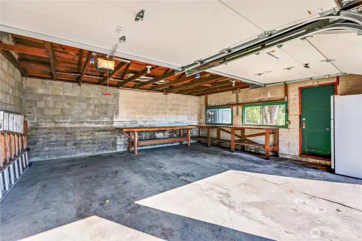 Garage has shop bench and refrigerator that stays.
