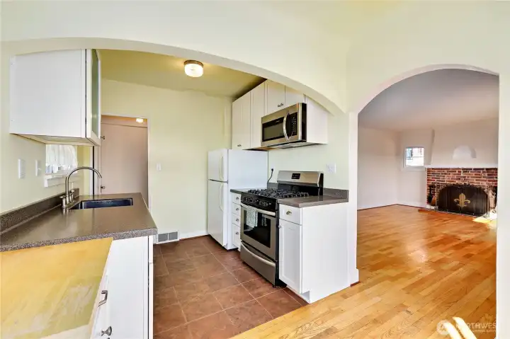 Updated kitchen with tile floors, Corian countertops, soft close cabinets, newer gas range, dishwasher and fridge.