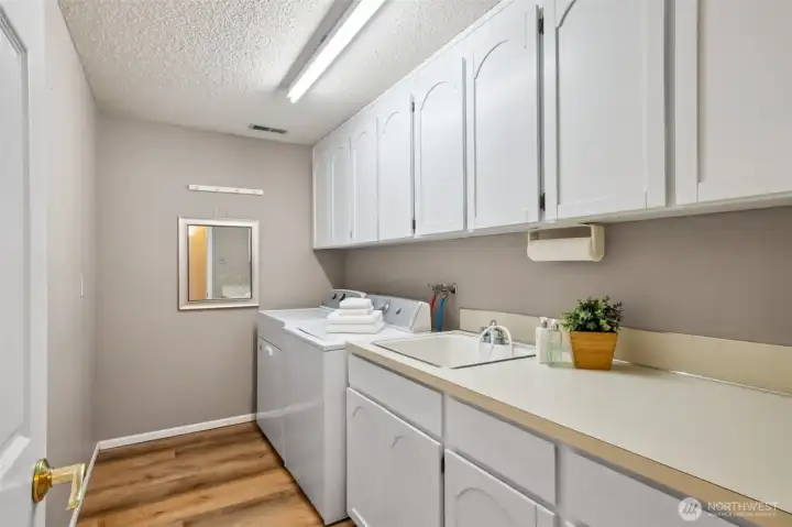 Large & practical laundry room! Loads of cabinets + sink!