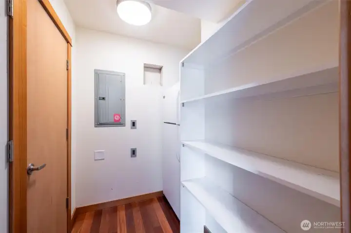 Pantry at rear of home, with included beverage refrigerator. Furnace and tankless water are behind doors to the left.