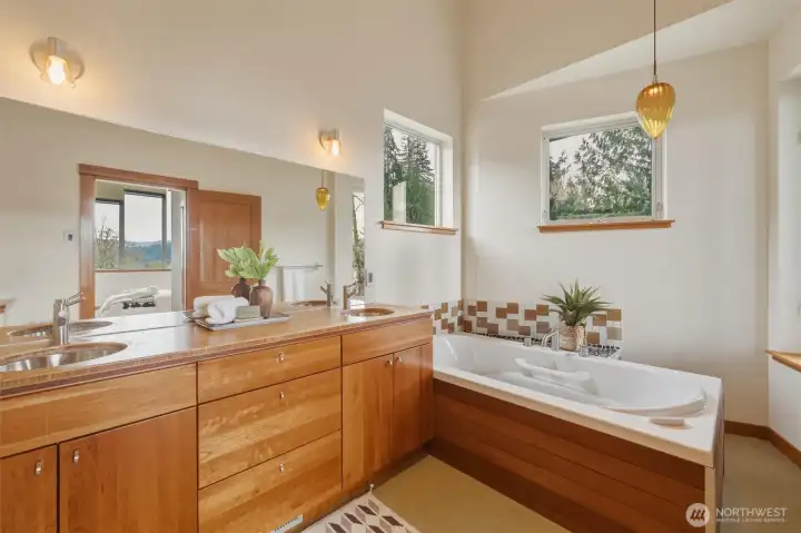 The ensuite is appointed with double vanity, large jetted soaker tub, and beautiful tiled shower accented with pebble floor and gorgeous green stone tile.