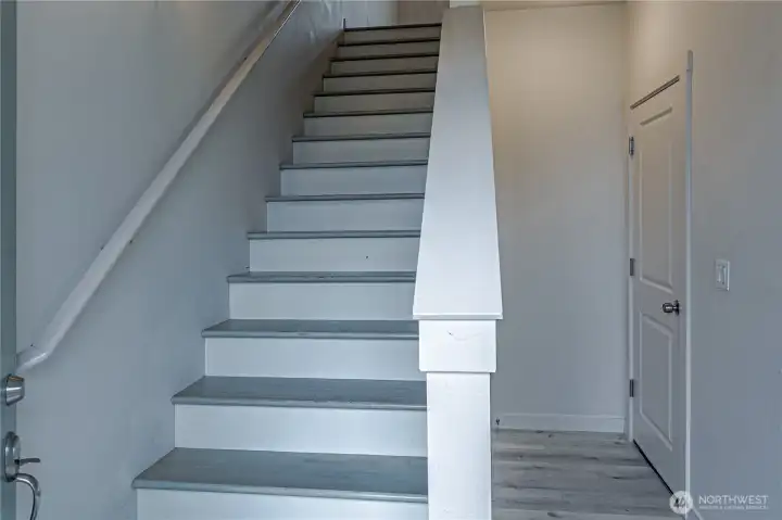 general photo of stairway up from garage entry.  New laminate floors throughout.