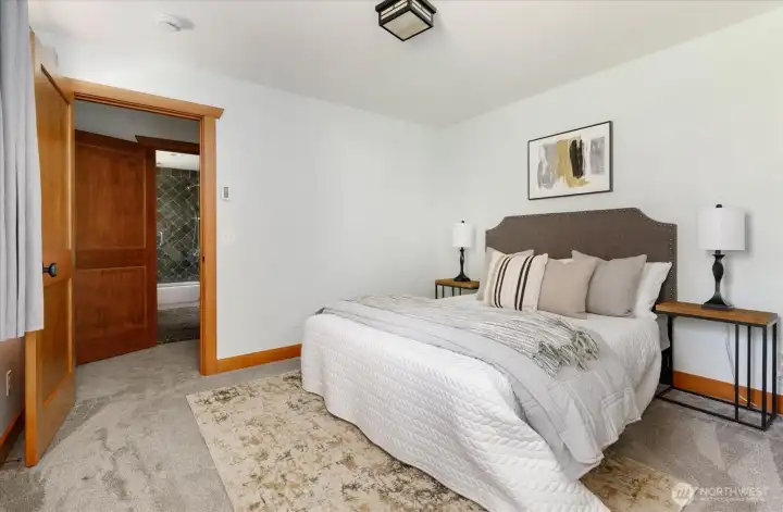 Main level bedroom showing door across hall to full bath