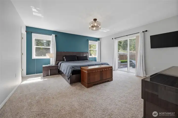 Primary bedroom with slider door out to patio