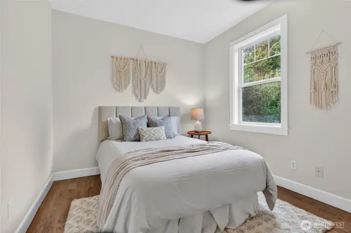 Bright, sunlit bedroom with large windows.