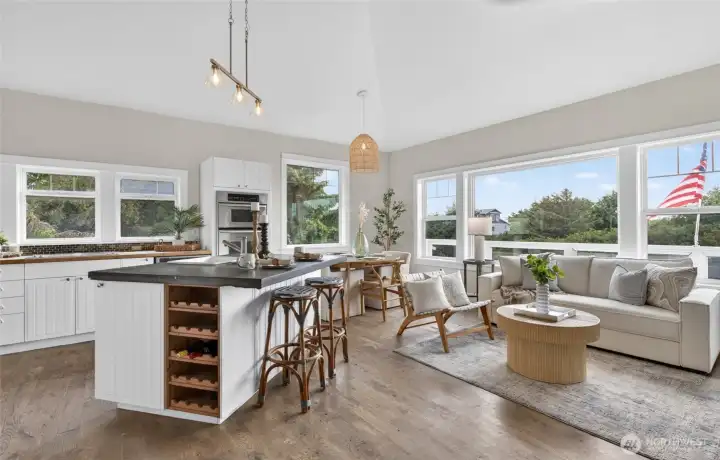 Kitchen island with dark countertop, barstools, and integrated wood wine rack