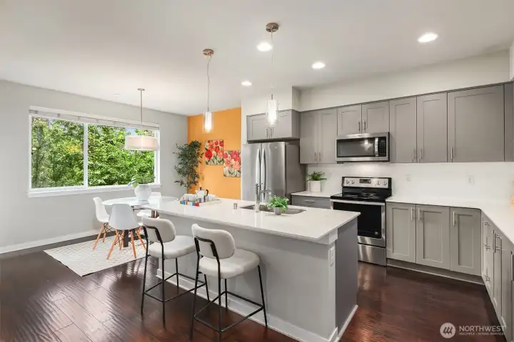 Chef's kitchen with abundant cabinetry and a large island eating bar that comfortably seats four people