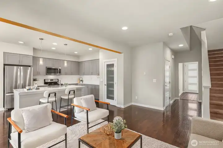 Open floor main with the entry in the back and stairs leading to the bedrooms on the upper floor