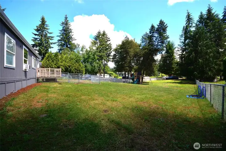 Another view of the spacious front yard highlighting its size, fencing, and outdoor potential