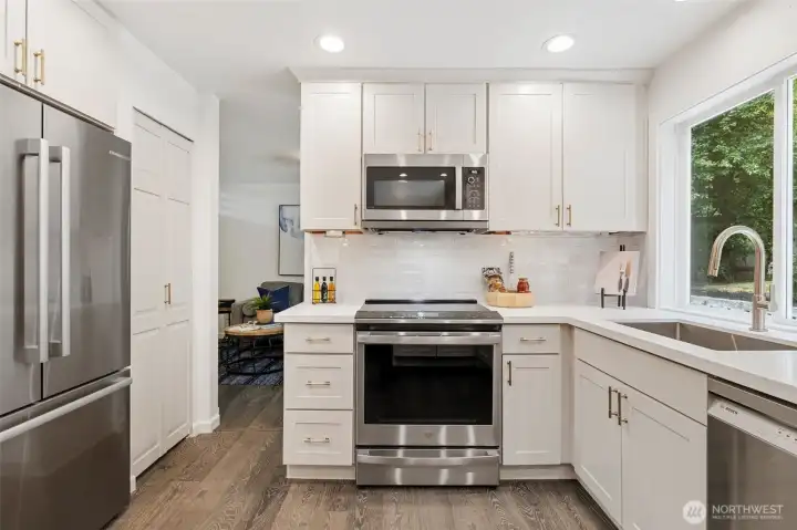 Back inside the updated kitchen has GE Profile Induction Range and Microhood with expanding vent. Back inside the updated kitchen has GE Profile Induction Range and Microhood with expanding vent.