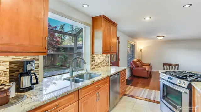 Enjoy ample counter space, generous cabinet storage, and a charming pop-out window above the sink.