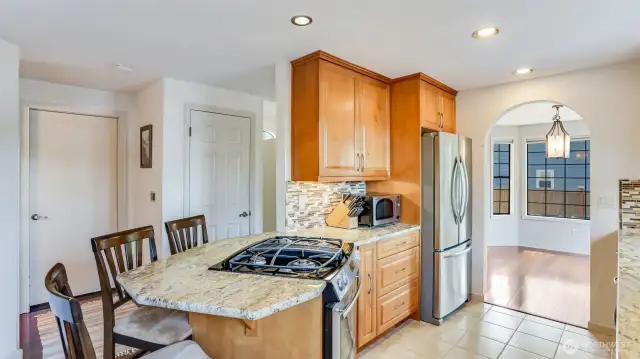 Kitchen features marble countertops, rich cabinetry, stainless steel appliances and peninsula with room for seating.