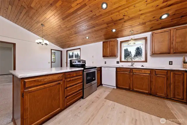 Newly updated kitchen with new stove, flooring, countertops, and backsplash.