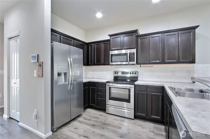Kitchen view, I love the contrasting cabinets with countertops, all appliances included, and to your left down the hall is your pantry.