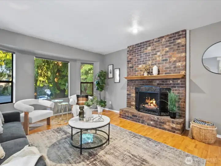 The living room is spacious and includes a bayed window and brick faced wood burning fireplace for cozy evenings.