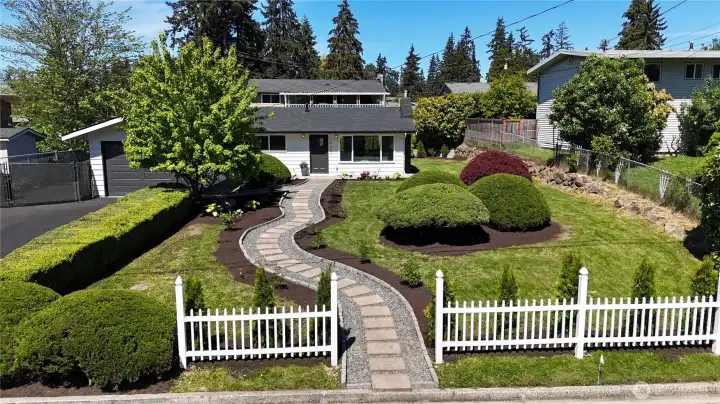 Welcoming curb appeal with manicured landscaping and a charming entry path. Image is from earlier listing in Sep 2025.