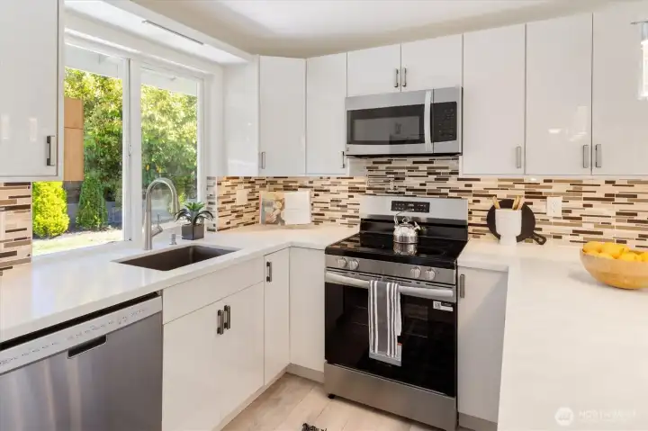 Updated kitchen with quartz countertops, custom cabinetry, and stainless appliances. Image from earlier listing in Sep 2025.