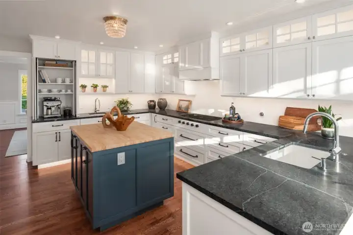 The gourmet kitchen is a chef’s dream, featuring custom cabinetry, rich soapstone countertops, and top-of-the-line appliances from Wolf, Sub-Zero, and Asko. Thoughtful details anticipate every need, with toe kick lighting, double sinks, and touch activated faucet