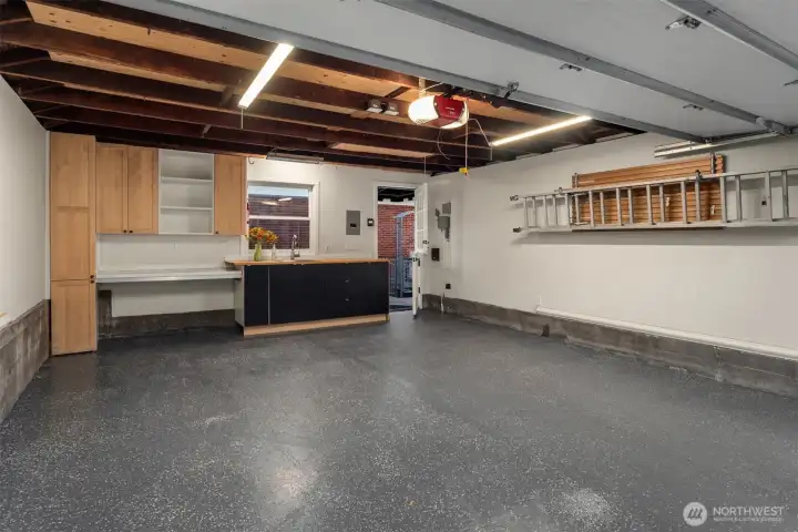 Two-car heated garage, sheet rock finished and epoxy flooring.  Work bench and cabinets for storage. Garage has  its own hot water tank with  hot and cold water available.   Pull down stair case for attic storage.