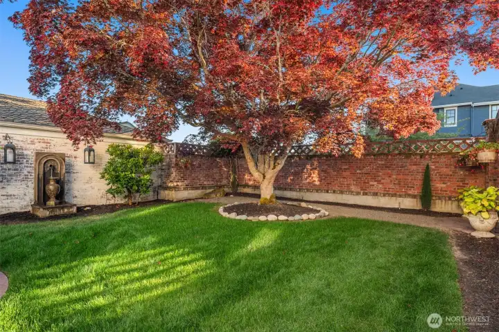 Step into the inviting backyard with old-world charm of a Tuscan villa, where dappled sunlight filters through mature maple trees. Ivy covered brick walls add privacy, making the patio with, BBQ grill,  the custom brick fireplace and pizza oven the perfect setting for sharing fine wine and memorable meals.