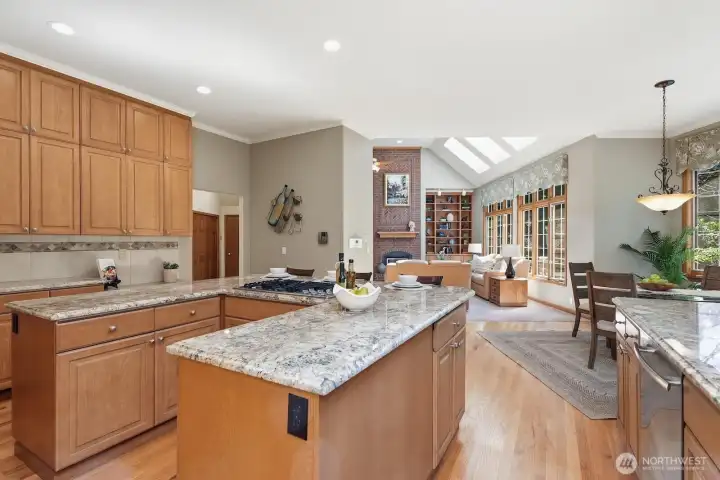 Floor to ceiling quality wood cabinetry, slab granite, breakfast bar seating, walk-in pantry open to the informal gathering area.