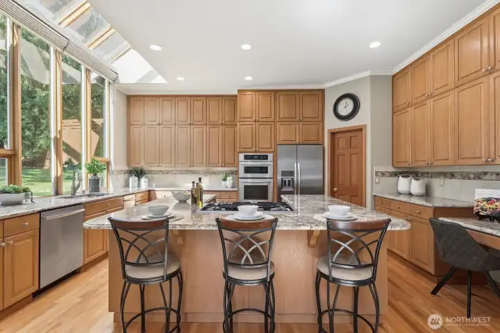 Breakfast bar seating, stainless appliances including a 5 burner gas stove, Jennair convection oven and separate microwave, Kitchen Aid refrigerator, trash compactor and dishwasher.