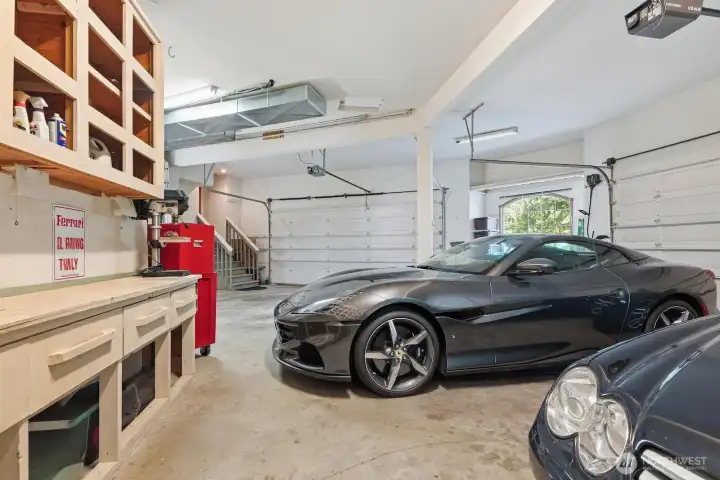 Oversized garage for 4 cars with tall ceilings, workbench, storage area and 2 double doors.
