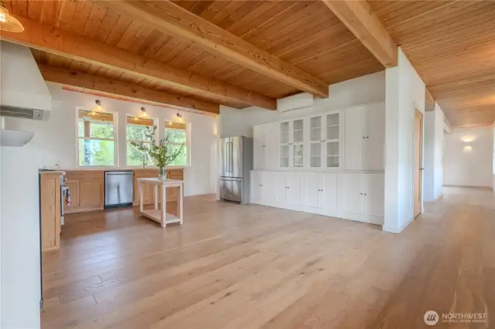 Positioned to capture bay facing light, the space offers a calm uncluttered aesthetic that reflects an intentional lifestyle. Generous proportions allow for an easy evolution into a more expansive culinary space. Existing layout comfortably accommodates large statement island with additional bank of cabinets flanking fireplace and connecting to a built in dining nook.