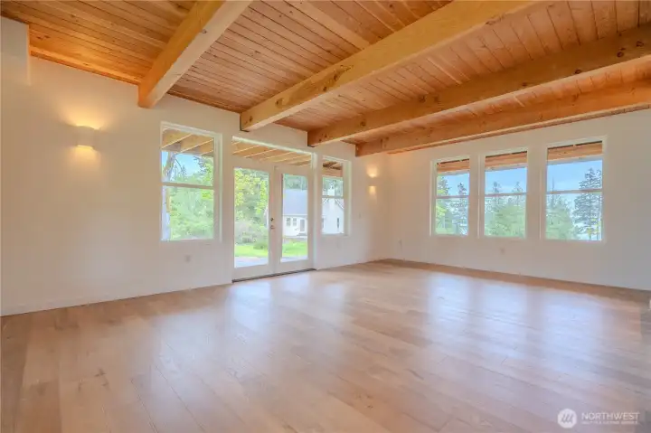 Warmth and volume define the main living spaces with exposed beam and tongue&groove ceilings paired with engineered white oak floors.