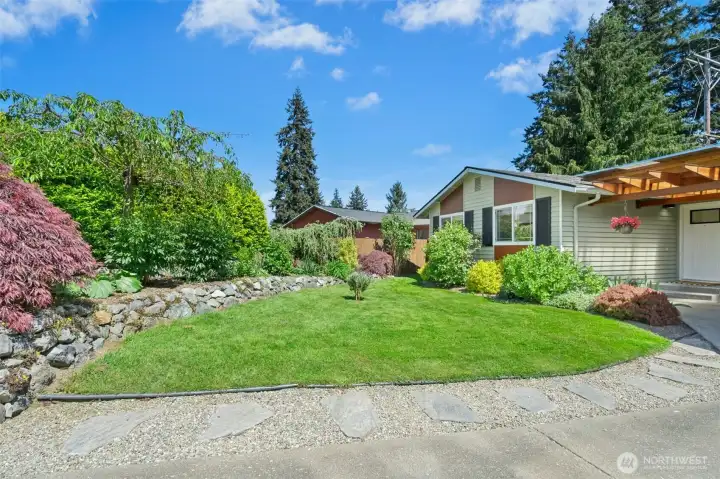 Beautiful manicured front yard w/ rockery for added privacy.